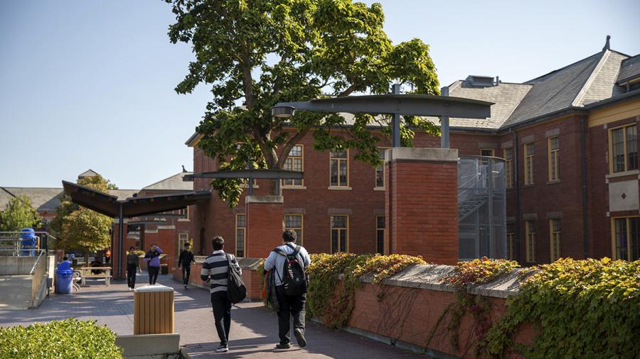 People walk together on a campus.